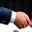 Two hands shaking over a contract.